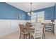 Dining room featuring a round wood table, bright window, and wainscotting at 4514 W Hazel Ln, San Tan Valley, AZ 85144