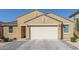 Close up of a beige home with a two-car garage, landscaped yard, and neutral color palette at 4514 W Hazel Ln, San Tan Valley, AZ 85144