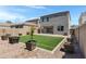 Inviting backyard featuring an artificial grass lawn, paver patio, and decorative potted trees at 4527 E Gagarinite Ln, San Tan Valley, AZ 85143