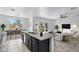 Stylish kitchen island with granite countertops, dark cabinets, and seamless flow to the dining and living areas at 4527 E Gagarinite Ln, San Tan Valley, AZ 85143