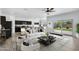 Open-concept living room with a sleek white sofa, modern decor, and seamless flow to the backyard at 4527 E Gagarinite Ln, San Tan Valley, AZ 85143