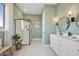 Light-filled bathroom with a glass-enclosed shower, modern vanity, and green walls at 477 E Aurora Dr, San Tan Valley, AZ 85140