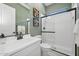 Stylish bathroom with a glass-enclosed shower, white vanity, and green walls at 477 E Aurora Dr, San Tan Valley, AZ 85140