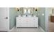 Elegant bathroom featuring a double vanity with decorative wall mirrors and green walls at 477 E Aurora Dr, San Tan Valley, AZ 85140