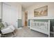 A charming Bedroom features a white crib and a comfortable rocking chair at 477 E Aurora Dr, San Tan Valley, AZ 85140