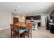 Bright kitchen featuring stainless steel appliances, dark cabinets, granite counters, and a dining table at 5341 W Alta Mesa Ave, Laveen, AZ 85339