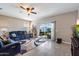 Bright living room with tile flooring, ceiling fan, blue sofa, and sliding glass doors to the backyard at 5341 W Alta Mesa Ave, Laveen, AZ 85339