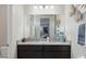Bathroom featuring dual sinks, dark cabinets, granite countertops, and decorative mirror at 5827 E Axle Ln, San Tan Valley, AZ 85140