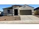 Charming single-story home featuring a neutral stucco facade, attached two-car garage, and low-maintenance landscaping at 5827 E Axle Ln, San Tan Valley, AZ 85140