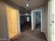 Hallway featuring tile and carpeted floors, connecting multiple rooms and offering ample access at 6341 W Valencia Dr, Laveen, AZ 85339