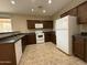 Functional kitchen with ample cabinet space, modern white appliances, and a practical tile floor at 6341 W Valencia Dr, Laveen, AZ 85339
