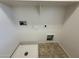 Well equipped laundry room showcasing tile flooring, shelving, and utility connections at 6341 W Valencia Dr, Laveen, AZ 85339