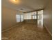 Spacious, light-filled living room with neutral walls, tile flooring, and ample natural light through bright windows at 6341 W Valencia Dr, Laveen, AZ 85339