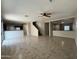 Open-concept layout connecting the living room, kitchen, and staircase, featuring tile flooring throughout the space at 6341 W Valencia Dr, Laveen, AZ 85339