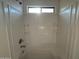 Close-up of a clean, well-lit shower-tub with built-in shelves and a small window at 6341 W Valencia Dr, Laveen, AZ 85339