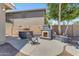 Outdoor fireplace, built in barbeque, and seating area in this charming backyard at 7129 S Stadium Way, Gilbert, AZ 85298