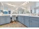 Bright bathroom featuring double vanity, large mirrors, stylish blue cabinets, and makeup station at 7129 S Stadium Way, Gilbert, AZ 85298