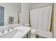 This bathroom includes a shower over tub with white tile surround, toilet, and a vanity with a gray cabinet at 7129 S Stadium Way, Gilbert, AZ 85298