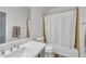 This bathroom includes a shower over tub with white tile surround, toilet, and a vanity with a gray cabinet at 7129 S Stadium Way, Gilbert, AZ 85298