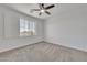 Well-lit, carpeted bedroom featuring a ceiling fan, white walls, and a window with shutters at 7129 S Stadium Way, Gilbert, AZ 85298