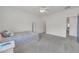 Spacious bedroom with neutral carpet, ceiling fan, a window, and simple furnishings, offers a relaxing retreat at 7129 S Stadium Way, Gilbert, AZ 85298