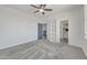 This bedroom features light gray carpet, white walls, a ceiling fan, and a decorative shelving unit at 7129 S Stadium Way, Gilbert, AZ 85298