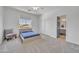 This bedroom features light gray carpet, white walls, a ceiling fan, and a gray chair and simple furnishings at 7129 S Stadium Way, Gilbert, AZ 85298