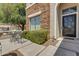 Charming front porch with a table, chairs, stone accents, and an elegant front door at 7129 S Stadium Way, Gilbert, AZ 85298