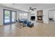Bright living room with a stone fireplace, ceiling fan, tiled floors, and a view to the pool at 7129 S Stadium Way, Gilbert, AZ 85298