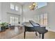 A grand living room featuring high ceilings, a piano, and large windows for ample natural light at 7129 S Stadium Way, Gilbert, AZ 85298