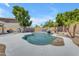 Beautiful in-ground pool features rock waterfall, trees, and spacious concrete patio area at 7129 S Stadium Way, Gilbert, AZ 85298