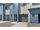 Townhome with gravel landscaping, a front entry door, a garage, and blue exterior accents at 7434 S 75Th Dr, Laveen, AZ 85339