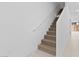 Interior view of the carpeted stairway with a white handrail and white walls at 7434 S 75Th Dr, Laveen, AZ 85339