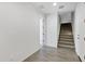Bright hallway featuring wood-look tile flooring, staircase, and a doorway leading to other rooms at 751 W Flintlock Way, Chandler, AZ 85286