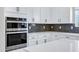 Close-up of stainless steel double ovens against a gray tiled backsplash and white cabinetry at 751 W Flintlock Way, Chandler, AZ 85286