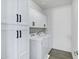 Well-lit laundry room features white cabinetry, modern appliances, and stylish gray tile floors at 751 W Flintlock Way, Chandler, AZ 85286