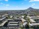 Stunning aerial view of community buildings, pool, and surrounding city skyline with picturesque mountains in the distance at 7625 E Camelback Rd # 310B, Scottsdale, AZ 85251