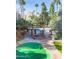 Community putting green and pool area with palm trees and lush desert landscaping at 7625 E Camelback Rd # 310B, Scottsdale, AZ 85251