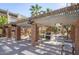 Outdoor grilling area with shaded seating, stainless steel grill, and decorative concrete pillars at 7625 E Camelback Rd # 310B, Scottsdale, AZ 85251