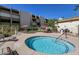 Community hot tub surrounded by lounge chairs, umbrellas, and landscaped green space at 7625 E Camelback Rd # 310B, Scottsdale, AZ 85251
