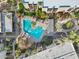 Aerial view of a bright turquoise pool surrounded by lounge chairs, umbrellas, and lush landscaping at 7625 E Camelback Rd # 310B, Scottsdale, AZ 85251