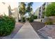 Exterior walkway surrounded by mature trees, greenery, and lovely manicured landscaping at 7625 E Camelback Rd # A139, Scottsdale, AZ 85251