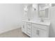 Modern bathroom with double sinks, white cabinetry, and sleek lighting fixtures at 7638 W Park St, Laveen, AZ 85339