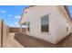 Side view of the house showcasing the exterior finish with windows and partial backyard view at 7638 W Park St, Laveen, AZ 85339