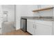 Wet bar with granite countertops, white cabinets, mini-fridge, and view of the adjacent room at 7638 W Park St, Laveen, AZ 85339