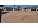 View of the backyard with dirt, old buildings, and palm trees at 7930 E Broadway Rd, Mesa, AZ 85208