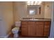 Cozy bathroom features a wooden vanity with granite counters, sink and toilet at 7930 E Broadway Rd, Mesa, AZ 85208