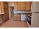 Functional kitchen with wood cabinets, white appliances, and tile flooring at 7930 E Broadway Rd, Mesa, AZ 85208