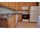 Functional kitchen with wood cabinets, white appliances, and tile flooring at 7930 E Broadway Rd, Mesa, AZ 85208