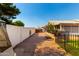 Side yard featuring a mix of gravel and greenery, with a white wall and gated fence at 8053 E Dover St, Mesa, AZ 85207